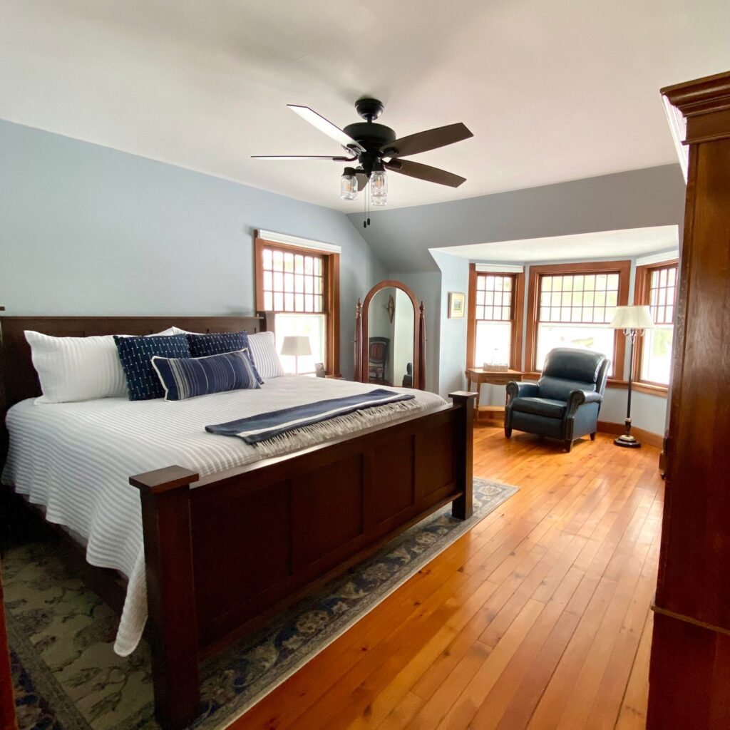 Canfield House Interior Guest Bedroom with ceiling fan, hardwood floors and many windows